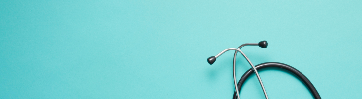 black stethoscope on light blue background