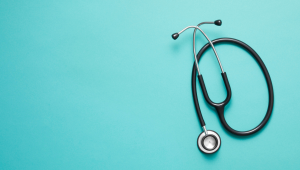 black stethoscope on light blue background